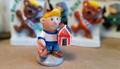Miniature sculpture representing little boy with a red cabin.