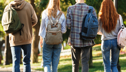 Neljä nuorta henkilöä kävelee rivissä reput selissään