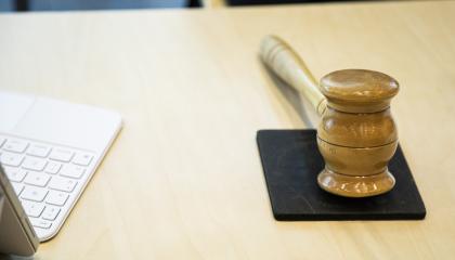 Kuvassa tietokonetta ja puheenjohtajan nuija.