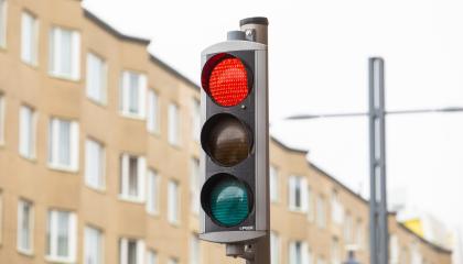 Liikennevalot, taustalla ruskea kerrostalo.
