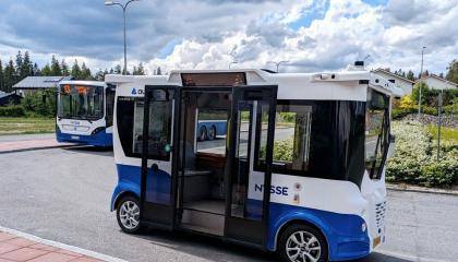 Pieni sinivalkoinen Nysse-automaattibussi, taustalla tavallinen Nysse-bussi.