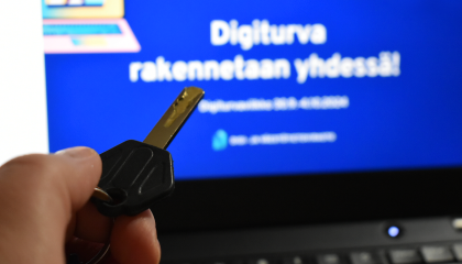 Digiturvaviikon teemasivu tietokoneella. Etualalla on avain.