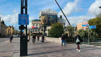 Pyöräopaste Hämeensillan valopylväässä, kävelijöitä ja pyöräilijöitä Hämeensillalla.