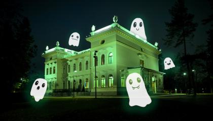 Vihreäksi valaistu Milavida kuvattuna ulkoa pimeällä. Rakennuksen ympärillä piirrettyjä kummituksia.