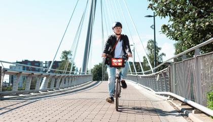 Mies ajaa kaupunkipyörällä Laukonsillalla Tampereella.