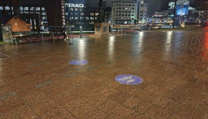 Jalkakäytävälle ja pyörätielle on heijastettu väyliä osoittavat liikennemerkit.