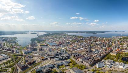 Kesäinen ilmakuva Tampereesta. Taustalla näkyvät järvet, edessä rakennuksia.
