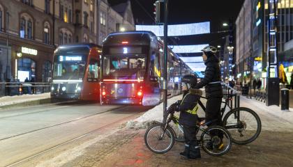 Kaksi raitiovaunua ja kaksi pyöräilijää talvisella Hämeenkadulla.