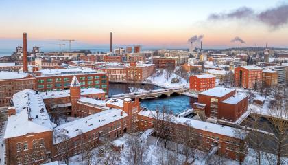 Talvinen näkymä ilmastakäsin Tampereen keskustasta, jossa punatiilisiä vanhoja rakennuksia etualalla.