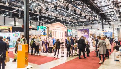 Paljon ihmisiä messuhallissa tutkimassa osastoja.