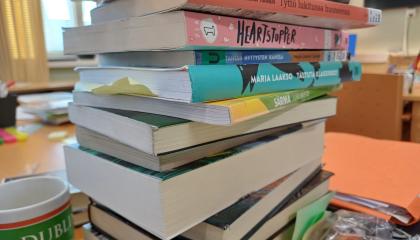 Korkea pino erilaisia kirjoja.