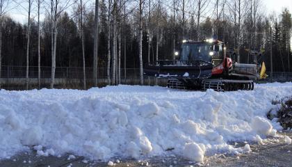 Latukone levittää lunta ladulle 
