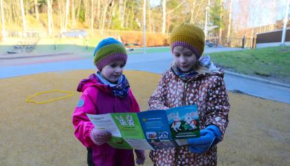 Kaksi lasta tutkii seikkailukarttaa.