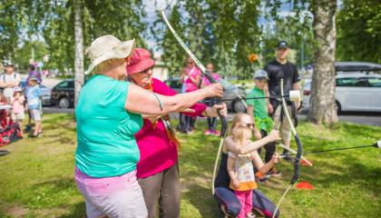 Ikäihminen opettelee jousiammuntaa