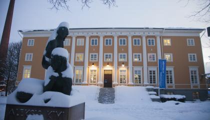 Suuri keltainen rakennus talvisessa maisemassa.