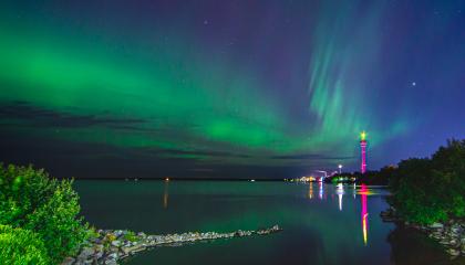 Kuvassa näkyy revontulet taivaalla ja yöllinen maisema Tampereelta.