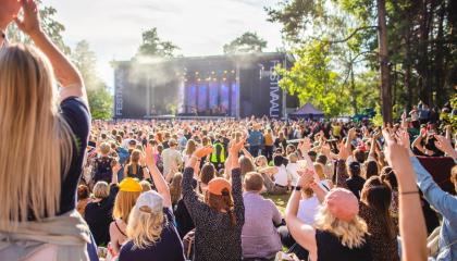 Festivaaliyleisöä etualalla, lava taka-alalla