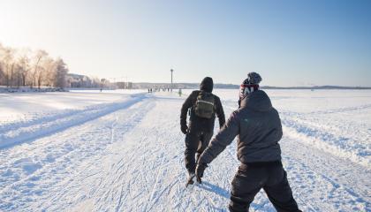 Ihmisiä luistelemassa Näsijärven jäällä kylmänä talvipäivänä. 