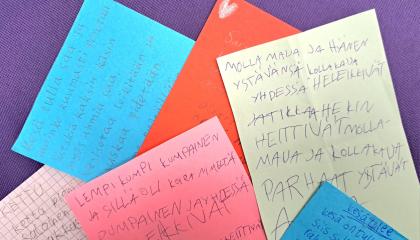 Eri värisiä papereita, joissa runotekstejä.