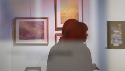 Kaksi henkilöä katsomassa taidenäyttelyä