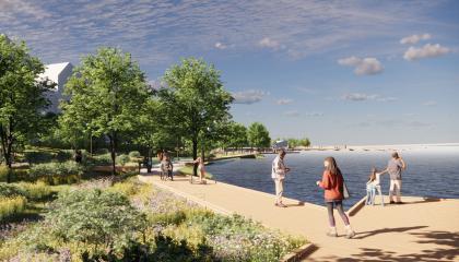 Kuvassa vasemmalla taloja, verhreä ja vihreä kesäinen laituripolku keskellä ja laitureja ja järvinäkymää oikealla.