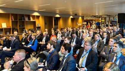 Yleisöä katsomossa kymmenittäin kuuntelemassa.