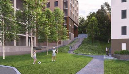 Lapsia pelaamassa palloa nurmella, taustalla kerrostaloja ja portaat rinteeseen.
