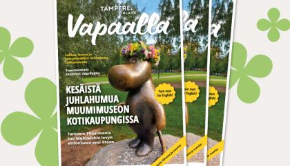 Kolme kesän 2025 Vapaalla-lehteä pinossa, taustalla graafisia neliapiloita. Lehden kannessa on pronssinen muumipeikko-patsas.