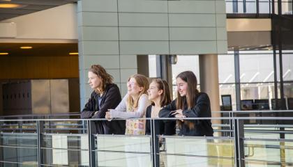 Neljä lukiolaista nojaa lukion yläkerroksen kaiteeseen