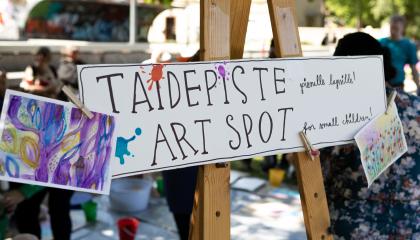 Kuva ulkotapahtuman taidepisteestä ja sen kyltistä.