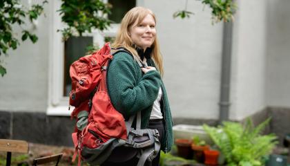 Henkilö rinkan kanssa pihalla.