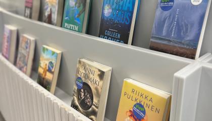 Kirjoja nojaa valkoista hyllyä vasten kannet katsojaan päin. Kansissa tarra &quot;Vippi&quot;.