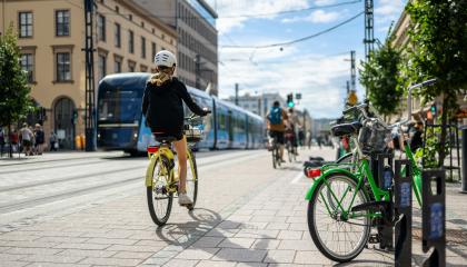 Pyöräilijöitä Hämeenkadulla, taustalla kulkee ratikka.