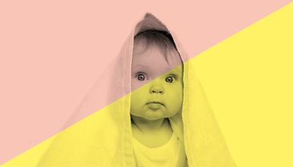 Vauva, jolla päänsä päällä pyyhe huppuna.