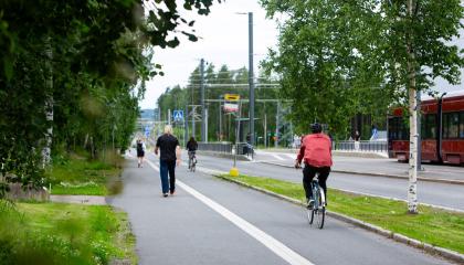 Jalankulkijoita ja polkupyöräilijöitä Hervannan Baanalla kesällä.