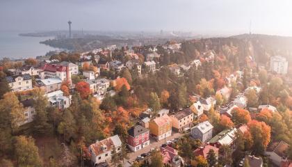 Syksyinen maisema, jossa on runsaasti taloja. Taustalla on järvi.