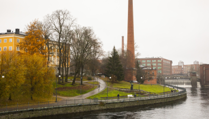 Maisemakuva, jossa Tammerkoski, punatiilinen piippu ja puiden takaa pilkottaa keltainen Vanha kirjastotalo.