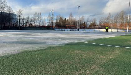 Kenttäalue, jossa osittain jäätä, osittain nurmea 