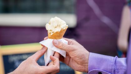 Kuvassa kaksi kättä, joista toinen ojentaa toiselle jäätelötötterön.