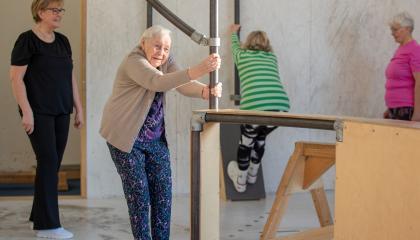 Neljä seniori-ikäistä naista liikuntasalissa.