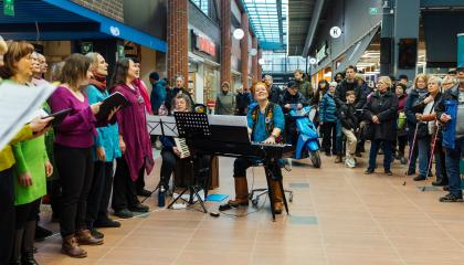 Kuoro esiintyy kauppakeskuksen aulassa.