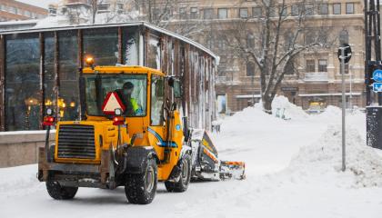 Auraustraktori lumitöissä keskustassa takaapäin kuvattuna.