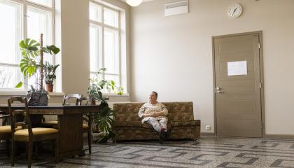 Annamaija Saarela istuu sohvalla Nekalan kulttuurikeskuksen käytävällä.