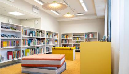 Yleiskuva Nekalan kirjastosta. Isoja kirja-aiheisia kalusteita ja kirjahyllyjä.