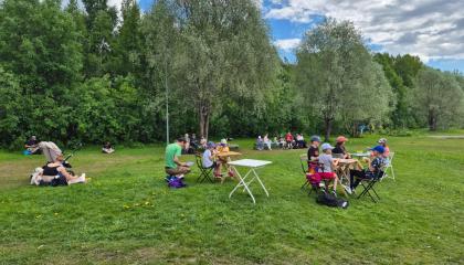 Ihmisiä ruokailemassa puistossa
