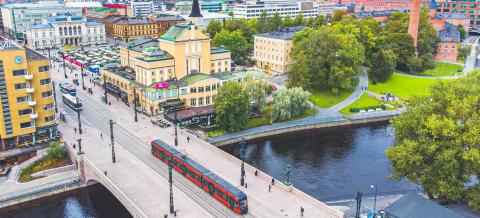 Drone-kuva Tampereen keskustassa. Kuvassa näkyy Hämeensiltaa, ratikka, Keskustoria ja Koskipuistoa.
