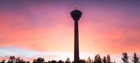 Tumma Näsinneulan torni punertavaa taivasta vasten.