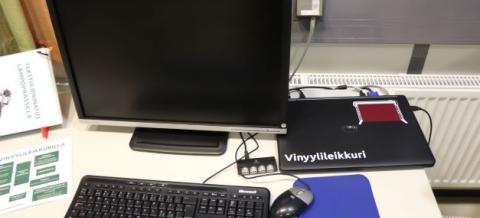 Piirtopöytä ja vinyylileikkuri Tekomon työpöydällä. 