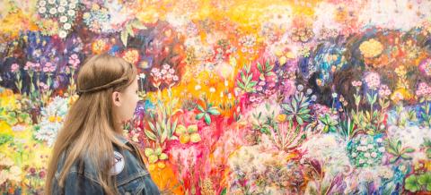 Nuori katselee taidemaalausta Sara Hildénin taidemuseossa.