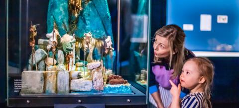 Vanhempi ja lapsi katselevat näyttelyä Muumimuseossa.